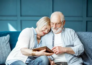 paar kijkt naar tablet in blauwe woonkamer